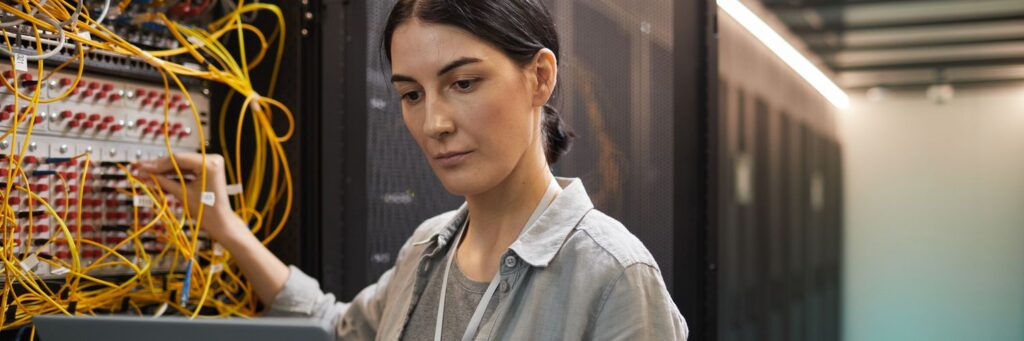 Female Network Technician Inspecting Servers in Data Center